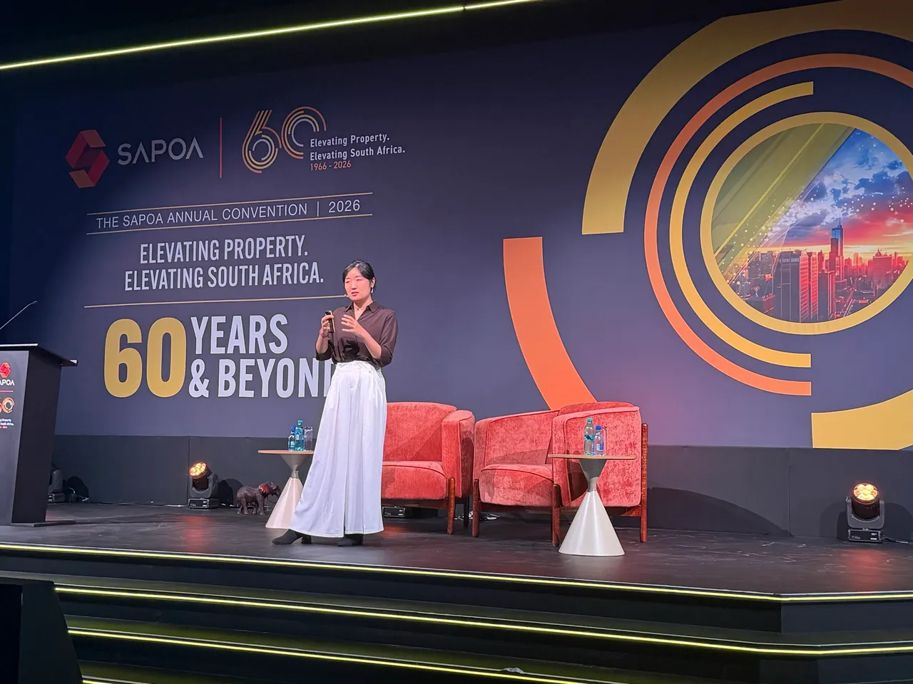 Yuehan Wang of JLL presenting on stage at the 2026 SAPOA Annual Convention, in front of a backdrop reading ‘60 Years & Beyond’
